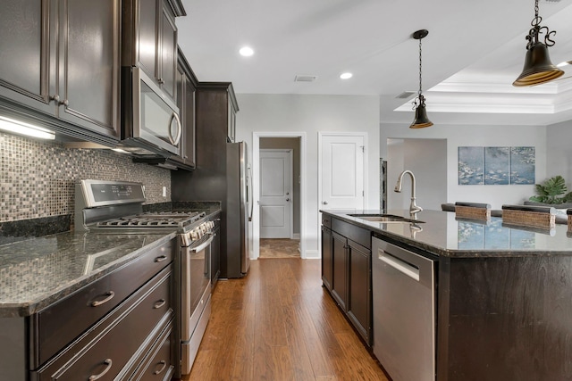 3260 Coneflower Dr, Tallahassee, FL 32311 - kitchen featuring appliances with stainless steel finishes, a sink, dark brown cabinets, dark wood-style flooring, and decorative backsplash