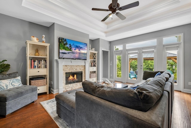 3260 Coneflower Dr, Tallahassee, FL 32311 - living room featuring a raised ceiling, crown molding, a fireplace, ceiling fan, and wood finished floors