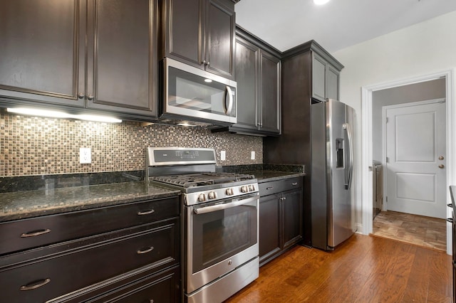 3260 Coneflower Dr, Tallahassee, FL 32311 - kitchen with stainless steel appliances, dark wood-style flooring, backsplash, dark stone countertops, and dark brown cabinetry