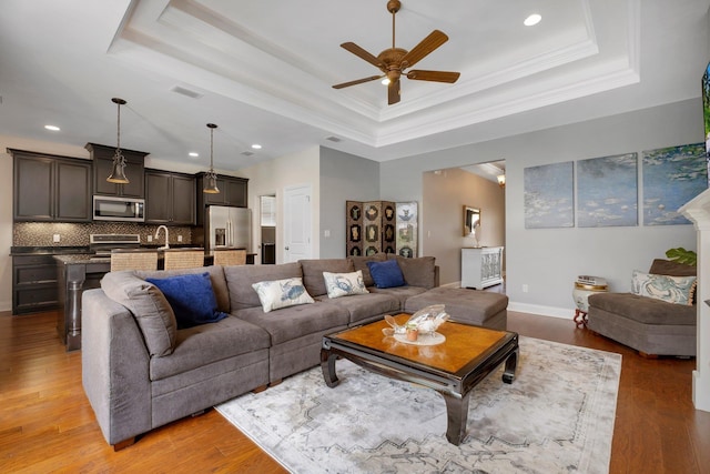 3260 Coneflower Dr, Tallahassee, FL 32311 - living room with a tray ceiling, a ceiling fan, light wood finished floors, recessed lighting, and baseboards