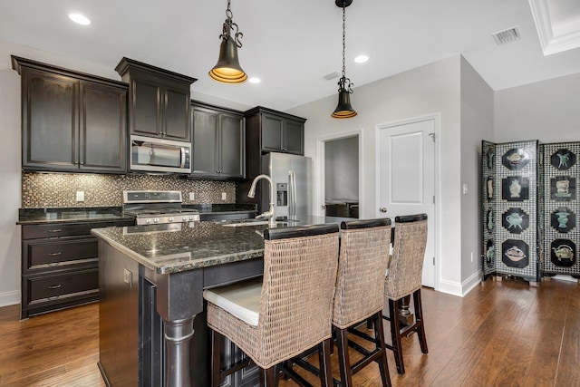3260 Coneflower Dr, Tallahassee, FL 32311 - kitchen featuring stainless steel appliances, a sink, a center island with sink, tasteful backsplash, and baseboards