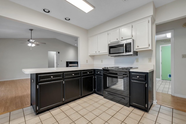 6557 Alan A Dale Trl, Leon, FL 32309 - kitchen with stainless steel microwave, black range with electric cooktop, dark cabinetry, white cabinets, and light countertops