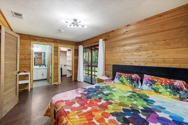 436 Tharpe Cir, Quincy, FL 32351 - bedroom with wooden walls, access to outside, dark wood-type flooring, a textured ceiling, and connected bathroom