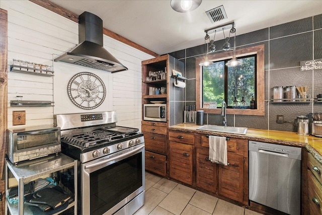 436 Tharpe Cir, Quincy, FL 32351 - kitchen featuring appliances with stainless steel finishes, island range hood, open shelves, brown cabinetry, and light countertops