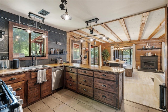 436 Tharpe Cir, Quincy, FL 32351 - kitchen featuring appliances with stainless steel finishes, brown cabinetry, stone counters, a peninsula, and wood walls