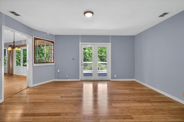 spare room with visible vents, light wood-type flooring, and a healthy amount of sunlight