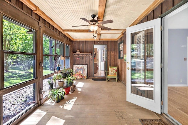 unfurnished sunroom featuring beam ceiling and ceiling fan