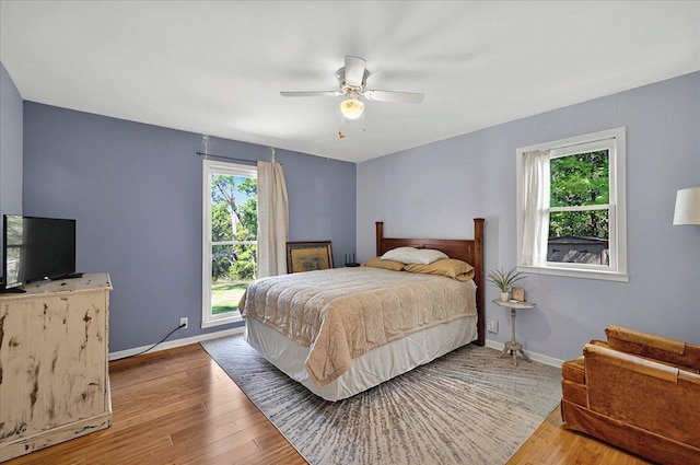 bedroom with wood finished floors, ceiling fan, and baseboards