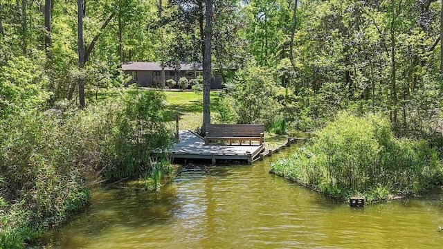 dock area with a water view and a wooded view