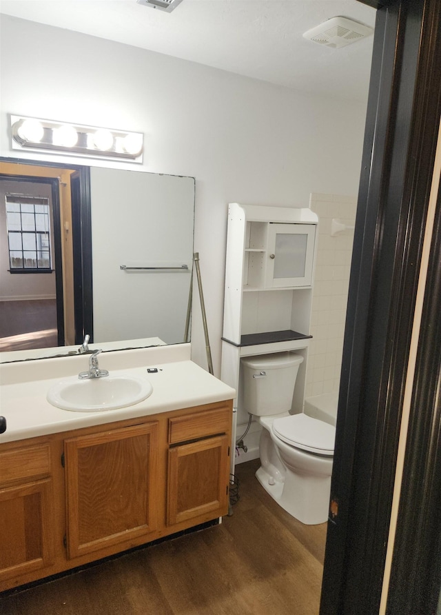 bathroom featuring vanity, hardwood / wood-style floors, and toilet