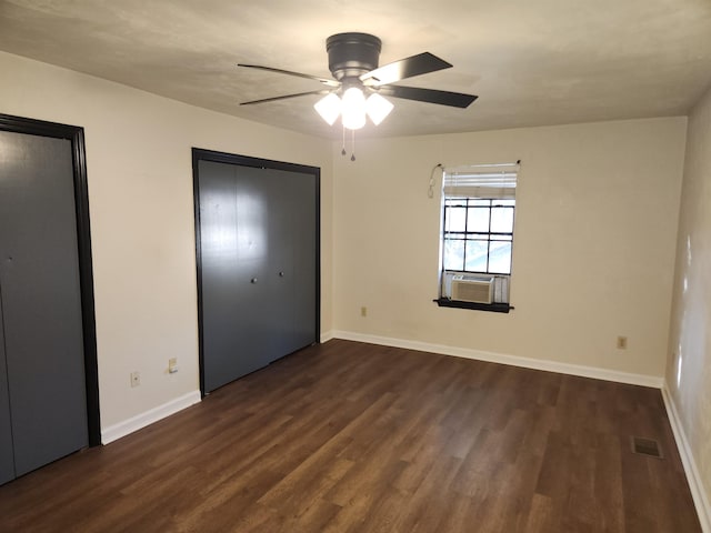 unfurnished bedroom featuring multiple closets, ceiling fan, cooling unit, and dark hardwood / wood-style flooring