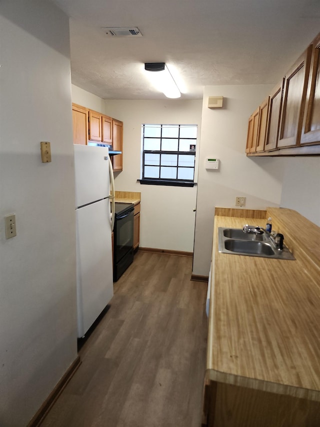 kitchen featuring sink, electric range, dark hardwood / wood-style floors, and white fridge