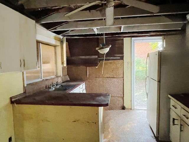 kitchen with white fridge, sink, and white cabinets