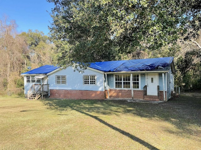 rear view of property featuring a yard and solar panels