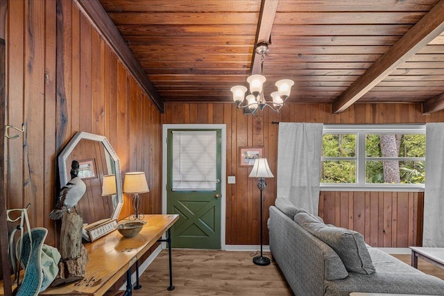 interior space with beam ceiling, wooden ceiling, an inviting chandelier, wooden walls, and light wood-type flooring