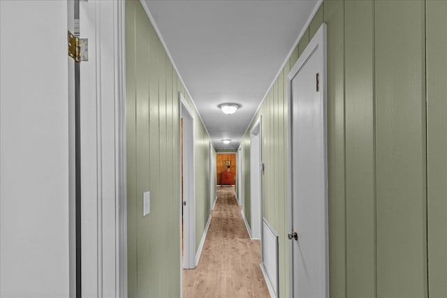 hallway with wooden walls and light wood-type flooring