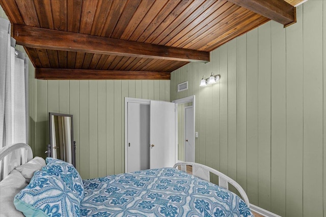 bedroom with beamed ceiling, wooden walls, and wood ceiling