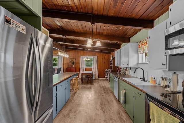 kitchen with pendant lighting, sink, appliances with stainless steel finishes, a notable chandelier, and wood ceiling