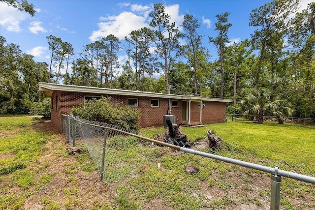 back of property featuring a lawn and central AC unit