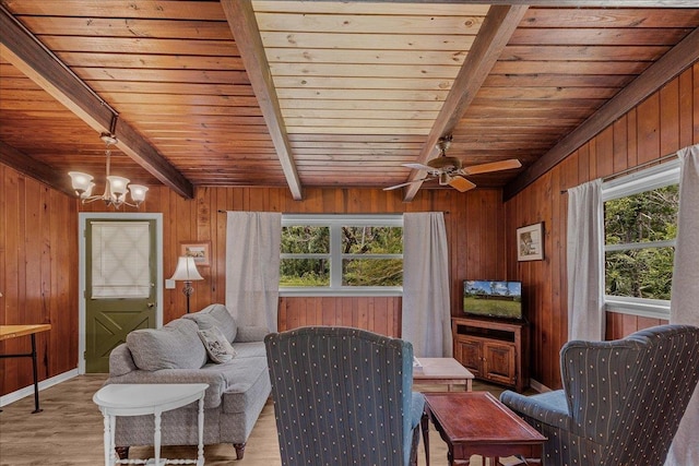 living room with beam ceiling, wood walls, light hardwood / wood-style flooring, and wooden ceiling