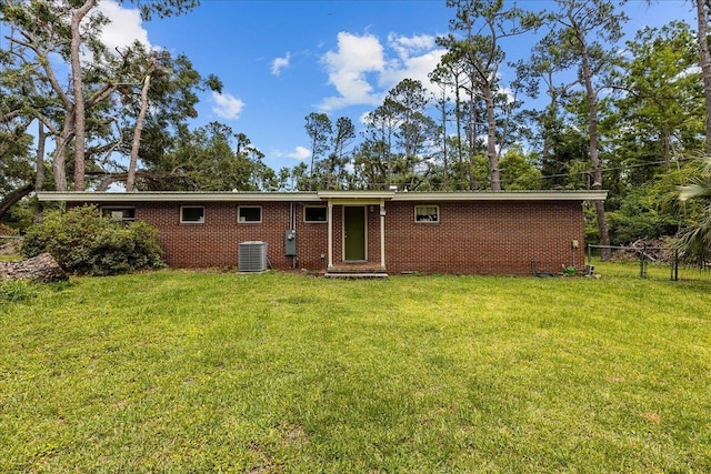 back of property featuring cooling unit and a lawn