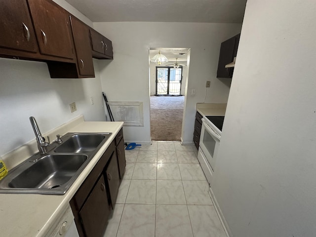 kitchen with light carpet, sink, dark brown cabinetry, and white range with electric cooktop