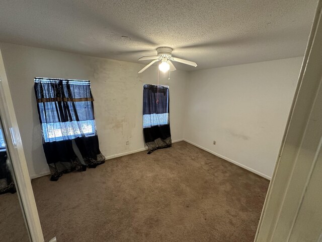 interior space with ceiling fan, carpet floors, and a textured ceiling