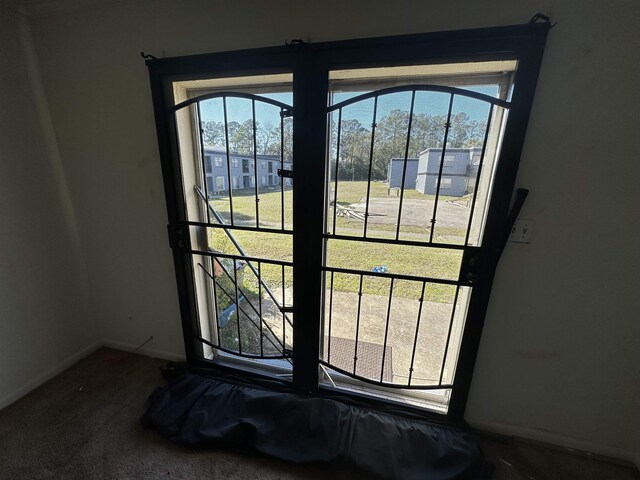 doorway featuring a wealth of natural light and carpet