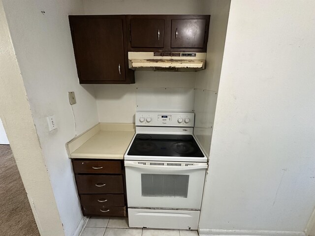 kitchen featuring electric stove, dark brown cabinetry, and light tile patterned flooring