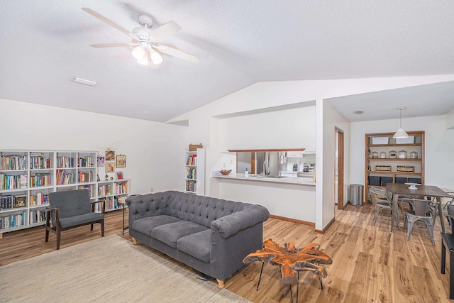 4308 Snoopy Ln, Tallahassee, FL 32303 - living room with lofted ceiling, ceiling fan, light wood-style flooring, and a textured ceiling