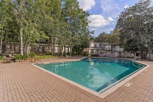 community pool featuring fence and a patio
