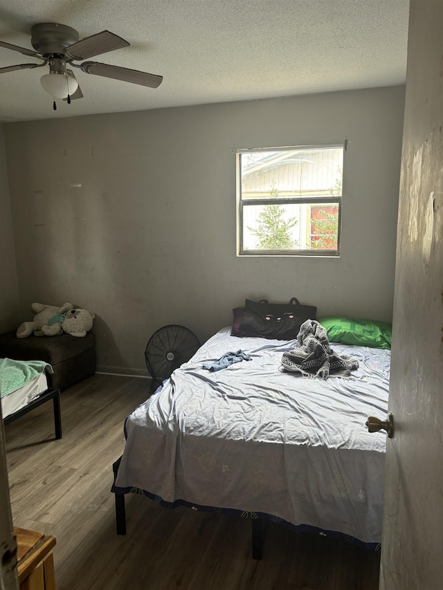 bedroom featuring a textured ceiling, ceiling fan, and light wood-type flooring