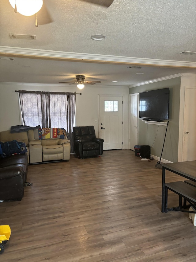 living room with ornamental molding, hardwood / wood-style floors, a textured ceiling, and ceiling fan