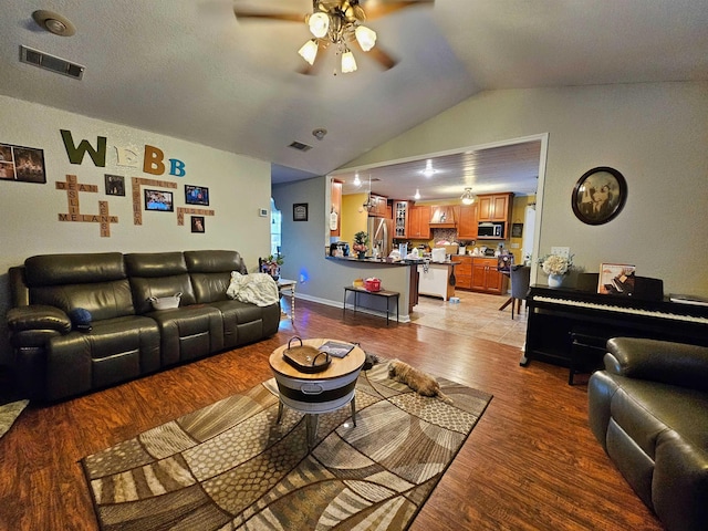 living room with lofted ceiling, light wood-type flooring, and ceiling fan