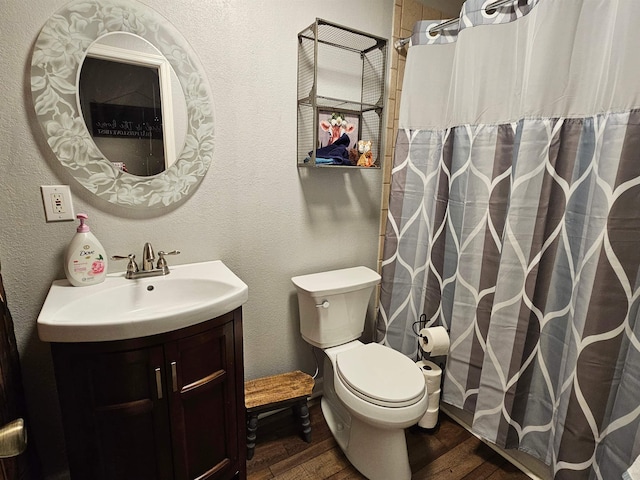 bathroom featuring hardwood / wood-style flooring, toilet, and vanity