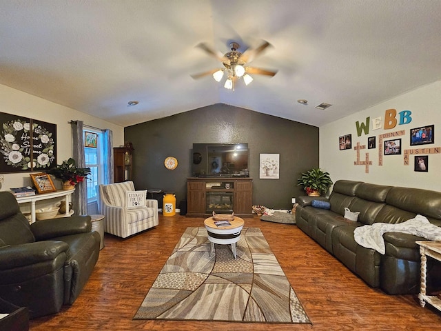 living room with vaulted ceiling, dark wood-type flooring, a fireplace, and ceiling fan