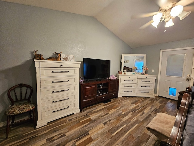 sitting room with ceiling fan, vaulted ceiling, and dark wood-type flooring