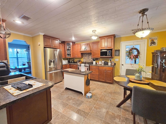 kitchen featuring decorative light fixtures, decorative backsplash, sink, appliances with stainless steel finishes, and ornamental molding