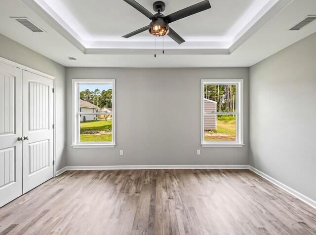 unfurnished bedroom with ceiling fan, multiple windows, and light hardwood / wood-style flooring