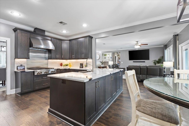 kitchen with crown molding, sink, stainless steel gas cooktop, and wall chimney range hood