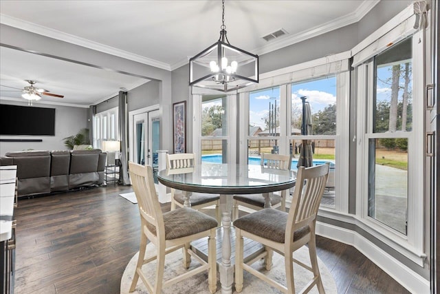 dining area with crown molding, ceiling fan with notable chandelier, and dark hardwood / wood-style flooring