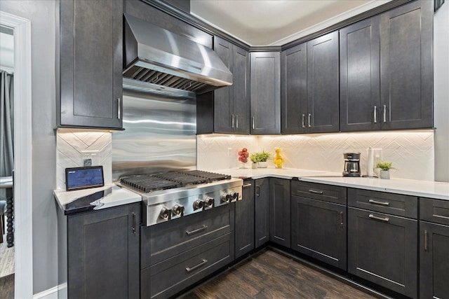 kitchen featuring stainless steel gas cooktop, wall chimney range hood, backsplash, and dark hardwood / wood-style flooring