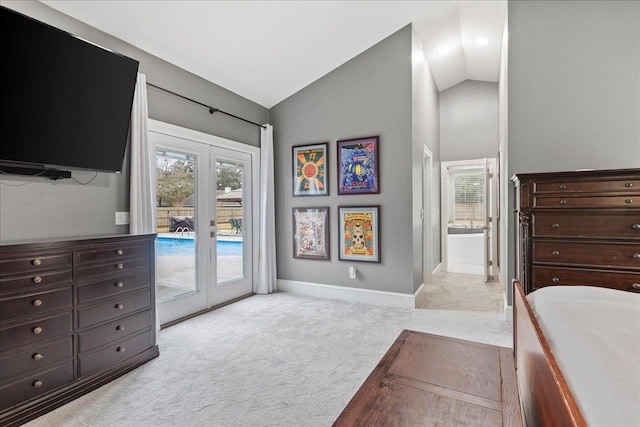 carpeted bedroom with connected bathroom, access to outside, french doors, and vaulted ceiling