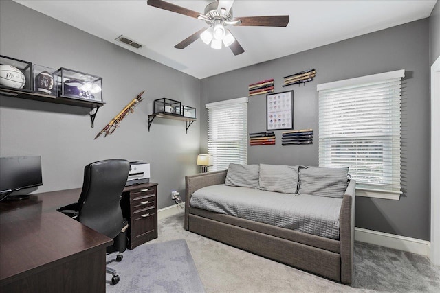 office area with a wealth of natural light, light carpet, and ceiling fan