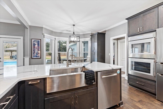 kitchen with pendant lighting, sink, crown molding, dark wood-type flooring, and stainless steel appliances