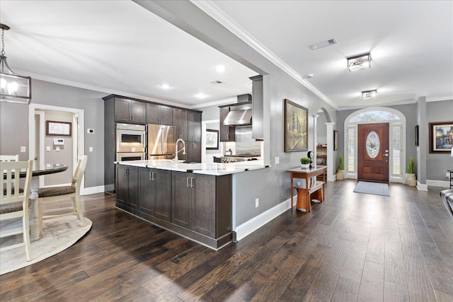 kitchen featuring hanging light fixtures, dark wood-type flooring, stainless steel fridge, and dark brown cabinetry