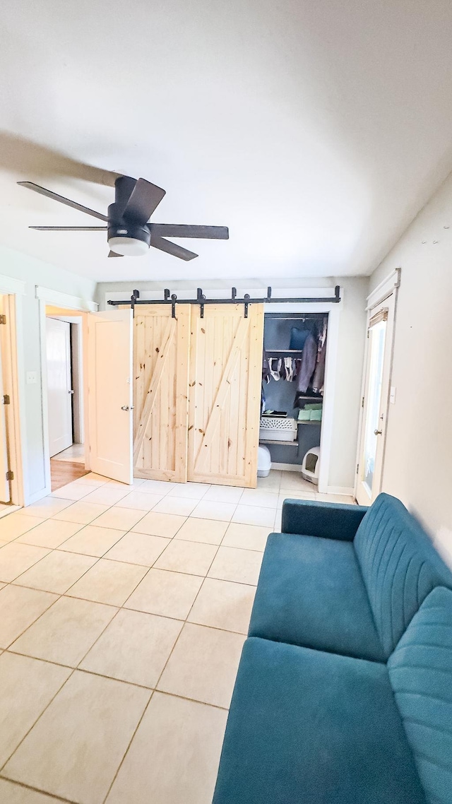 1839 Meriadoc Rd, Tallahassee, FL 32303 - living room featuring a barn door, ceiling fan, and light tile patterned flooring