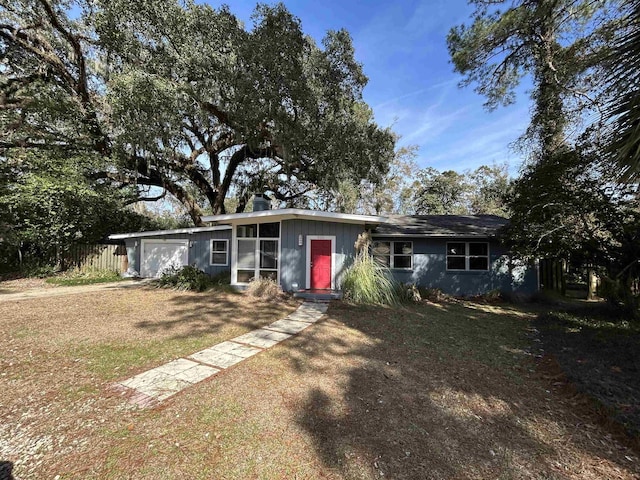 ranch-style home featuring a garage and a front lawn