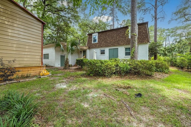 930 Maplewood Ave, Tallahassee, FL 32303 - back of house with mansard roof, roof with shingles, brick siding, and a yard