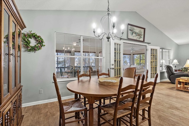 dining room with french doors, high vaulted ceiling, an inviting chandelier, and hardwood / wood-style floors